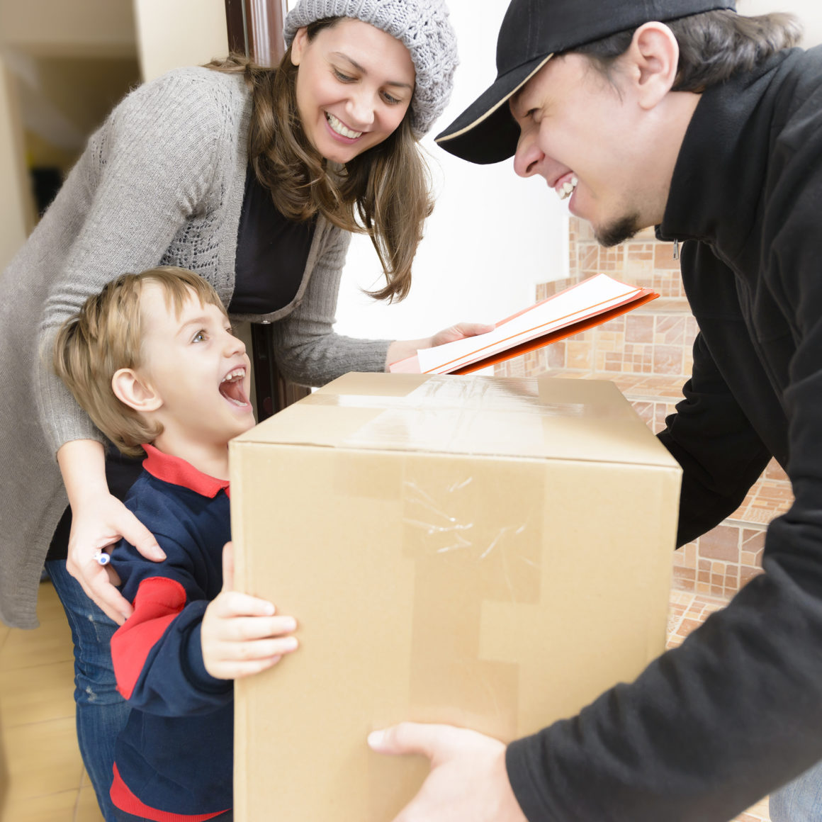 happy child and mother receiving a package from a happy delivery man